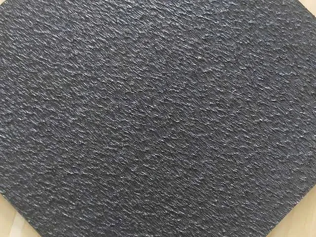Workers installing a black geomembrane liner at an engineering site
